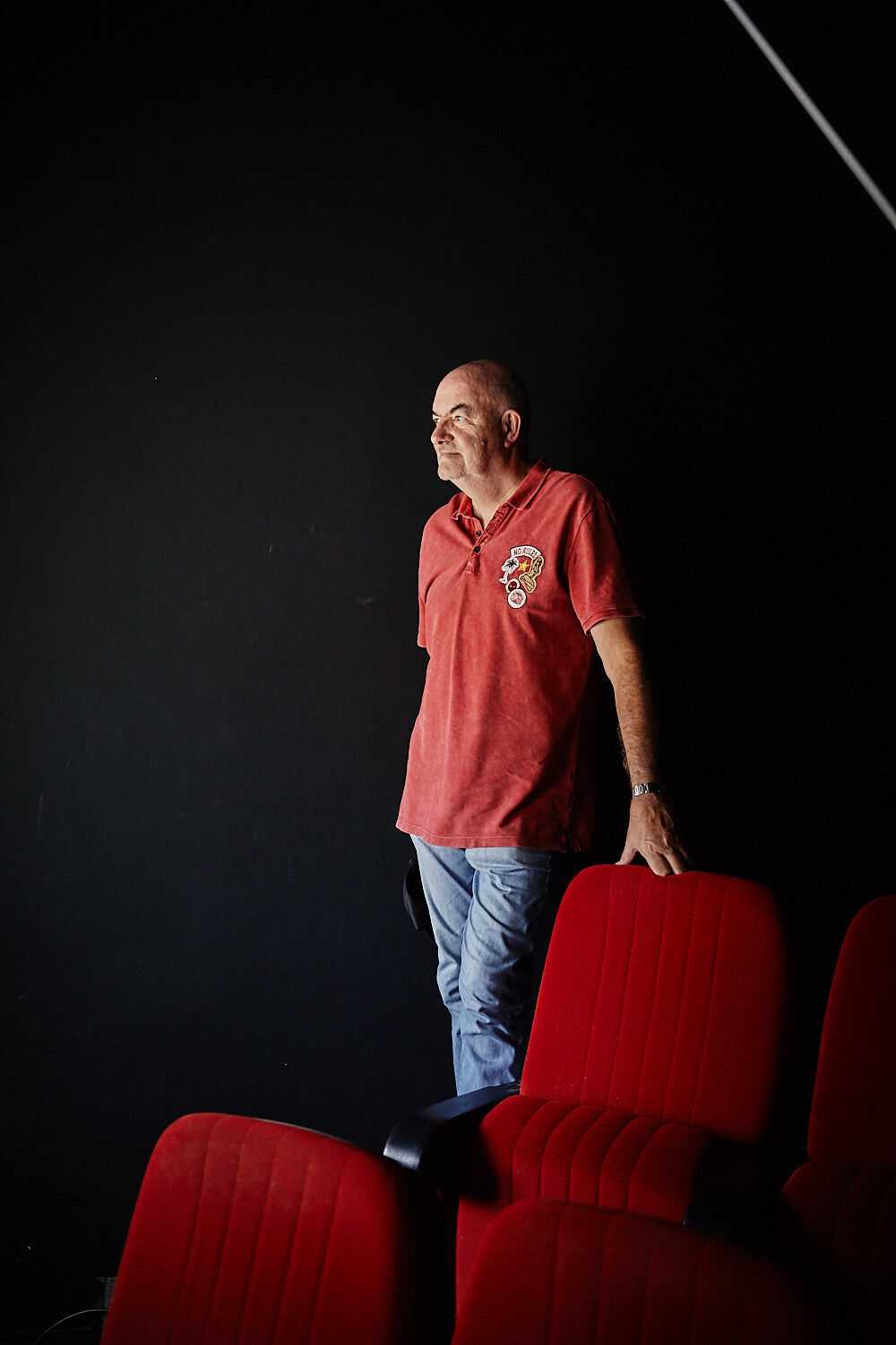 Thomas Zauner, Gründer des Unternehmens Scanline, lehnt in Kinosaal an einem roten Kinosessel