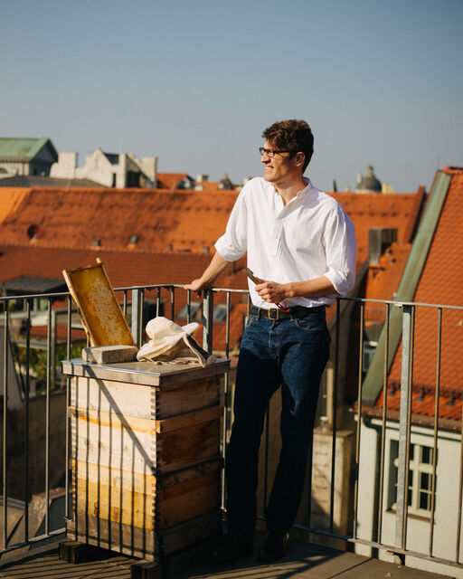 Kriminalrat Jürgen Brandl steht neben Bienenstock auf dem Dach des Münchner Polizeipräsidiums