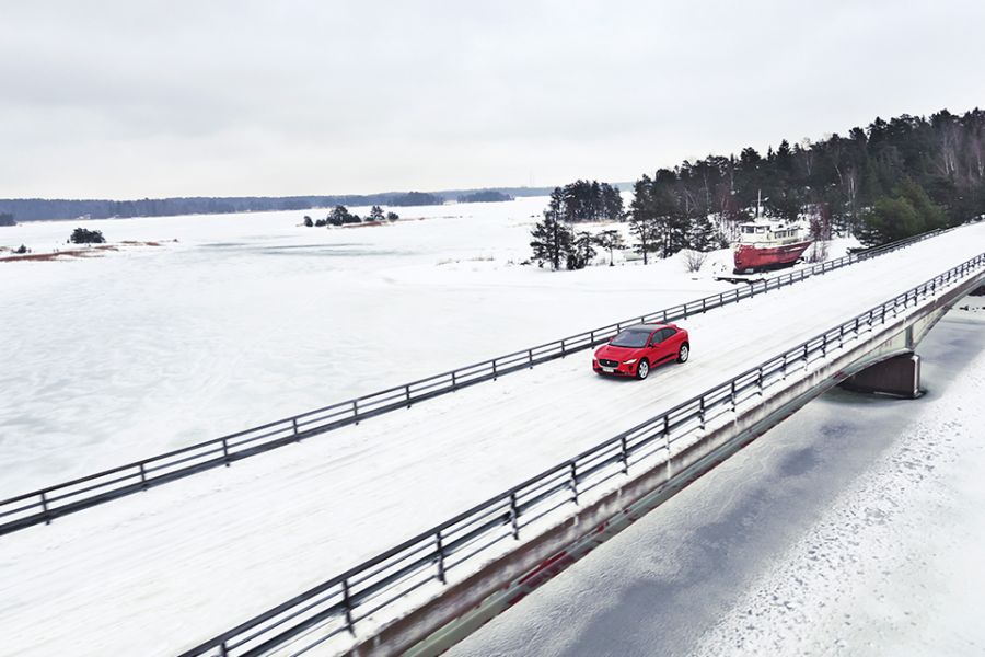Der Jaguar I-Pace fährt auf einer verschneiten Brücke über den größten See Finnlands