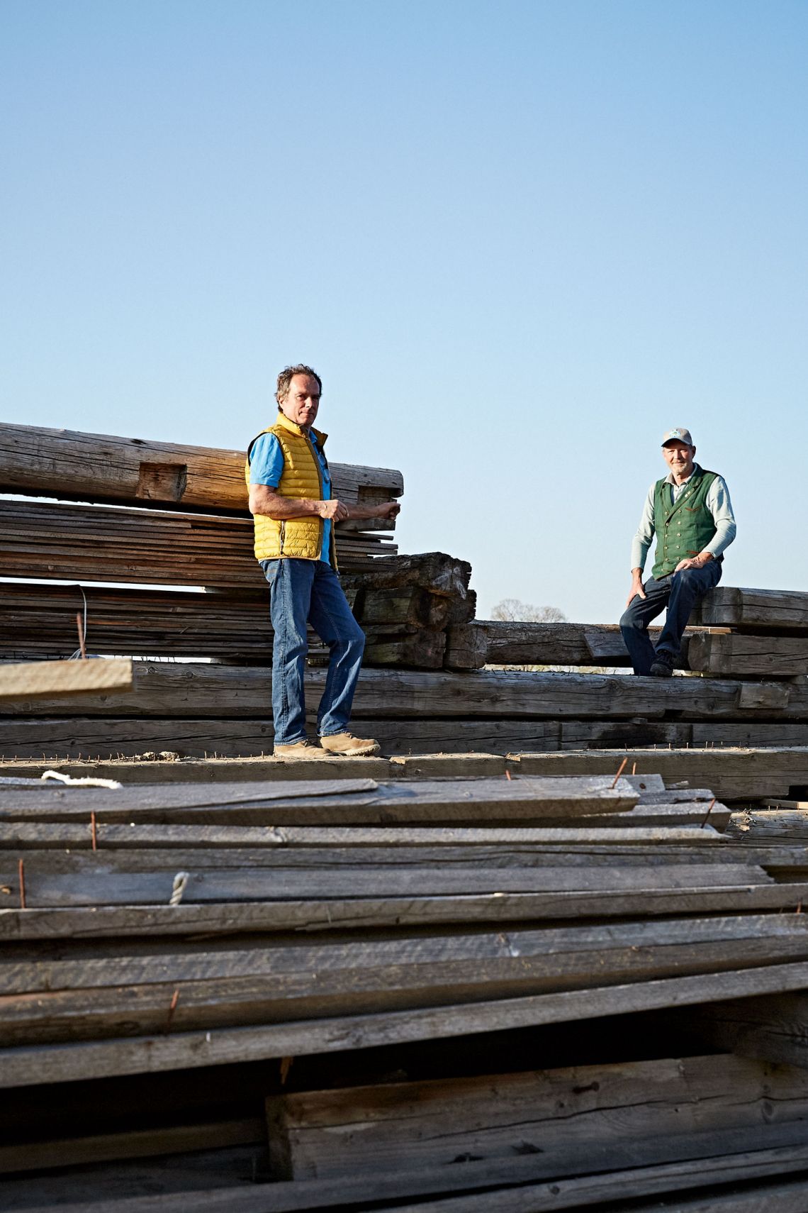 Anderl und Karl-Michael Friedinger stehen auf Holzbrettern auf Baustelle