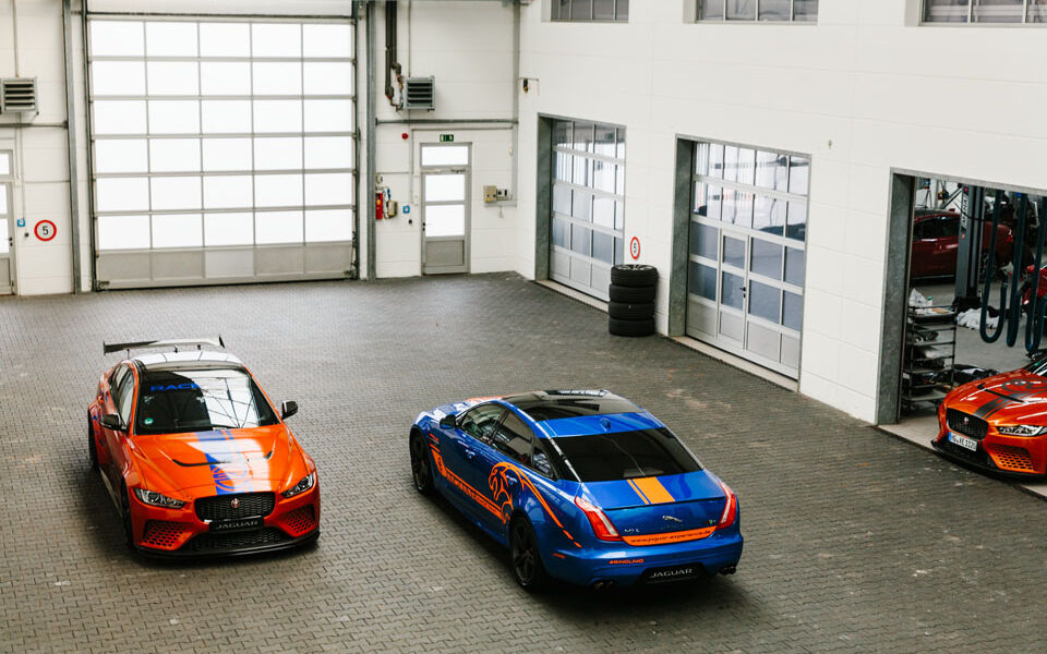 Blue and orange Jaguar in a car garage photographed from above