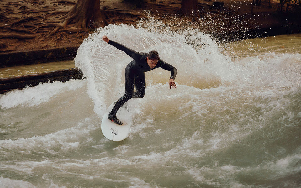 Sebastian Kuhn nimmt eine Kurve beim Surfen auf der Eisbachwelle