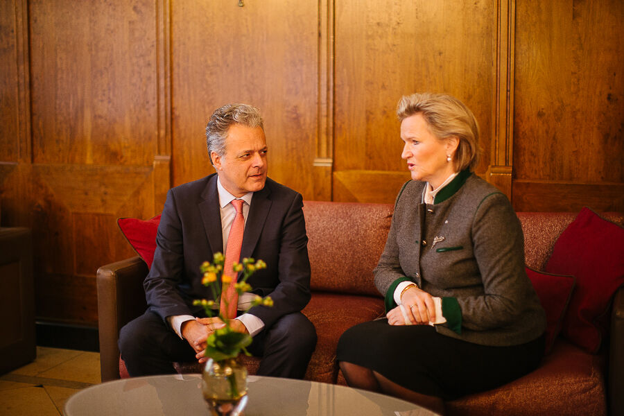 Angela Inselkammer and Harald Pechlaner sit on a red couch and talk