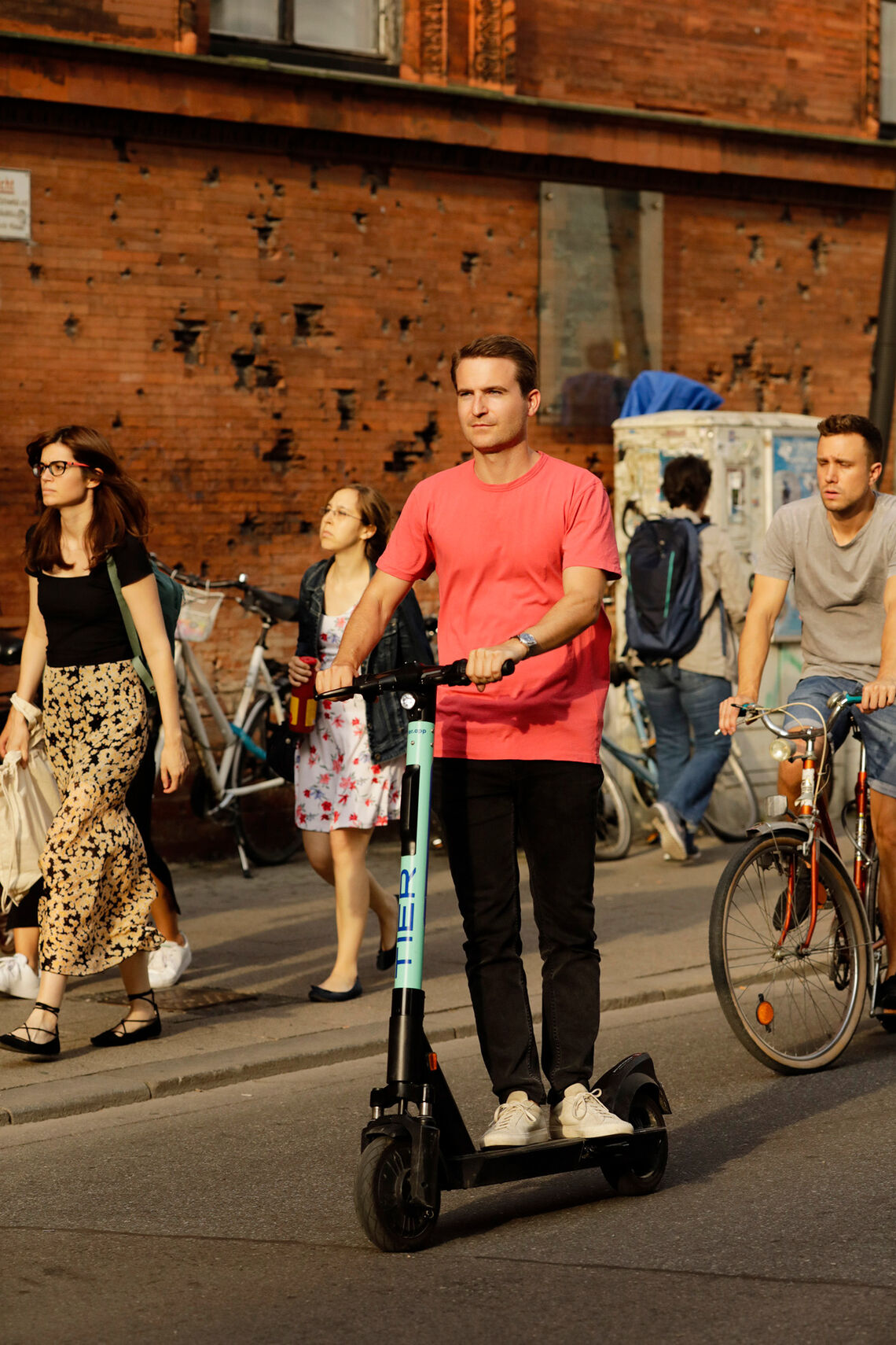 Balthasar Scheder fährt mit einem E-Scooter der Marke Tier an der Münchner Universität vorbei