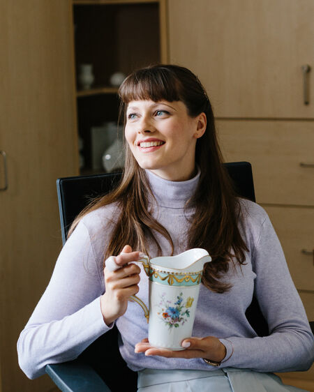 KPM employee Marleen Hamann sitting at her office desk with a Kurland water jug in her hands