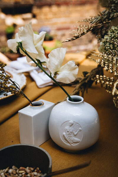 Zwei verschiedene KPM-Vasen mit filigranen Blumen als Deko auf dem Tisch