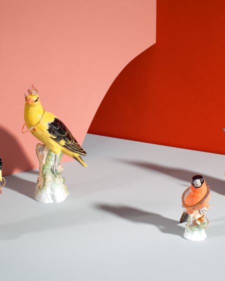 Four different KPM porcelain birds decorated with rings, bracelets and a chain by Wempe