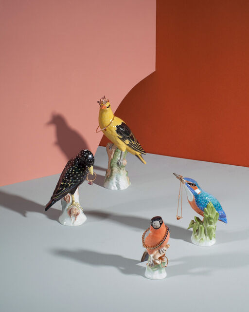 Four different KPM porcelain birds wearing rings, bracelets and a chain by Wempe