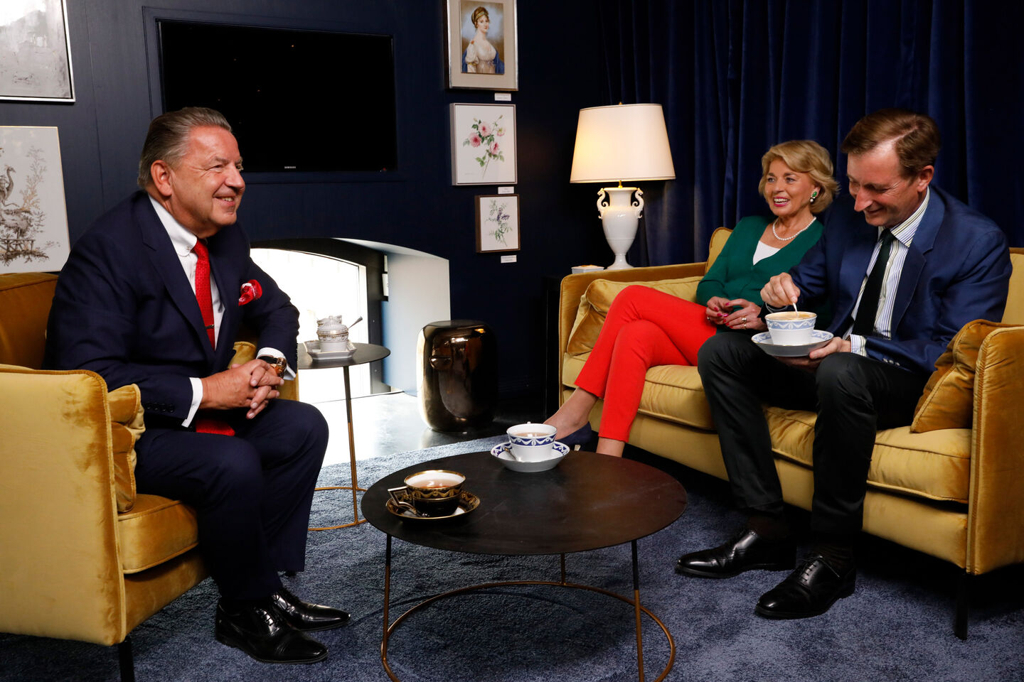 Jörg Woltmann, Tini Countess Rothkirch and Gerhard Schöningh sitting on light yellow velvet sofas, having a conversation