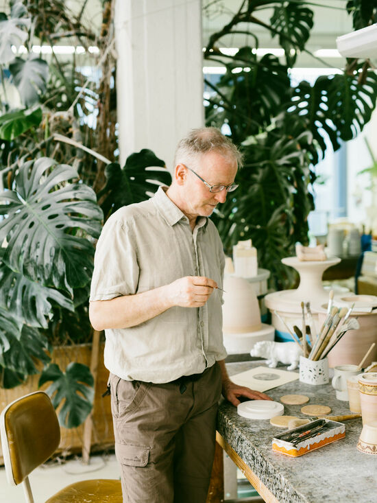 Marek Lipowski standing at his workplace with a brush in his hand