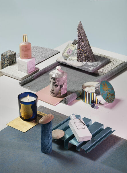 Still life with candles, bath salts, perfume, shower gel and soap on surfaces in grey, pink and blue