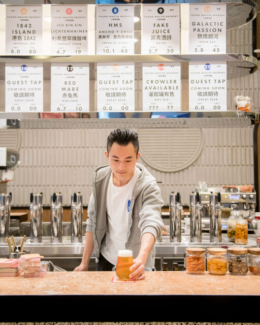 Chinese Bartender puts a glass of beer on bar counter