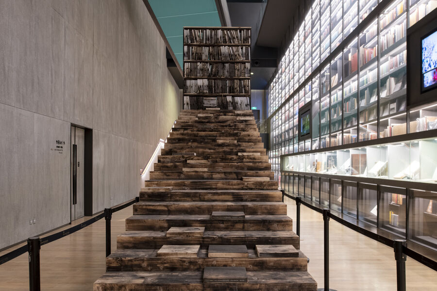 Interior view of the Artron Art Centre in Shenzhen with a staircase of books