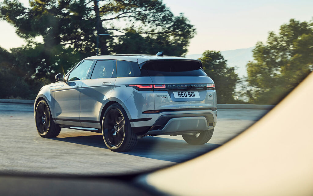 Range Rover Evoque, aus einem anderen Auto heraus fotografiert, fährt auf von Bäumen gesäumter Straße