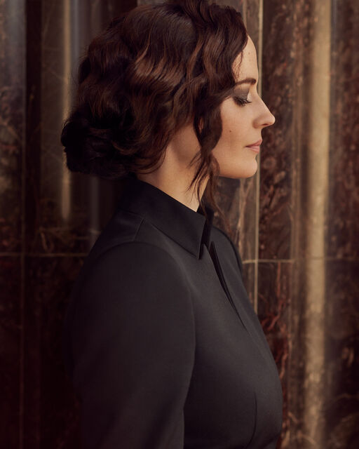 Lateral portrait of Eva Green with chignon and high-necked black blouse