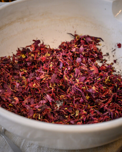 Rote und gelbe getrocknete Blüten in großer weißer Apothekerschale