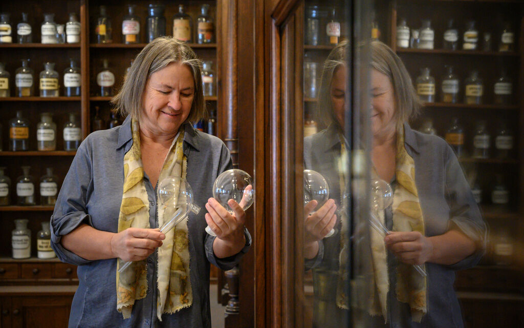 Martina Gebhardt stands in the pharmacy of the monastery Wessobrunn and looks at a jar with natural cosmetics