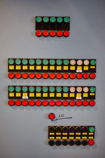 Control panel with several green and red buttons and yellow labels