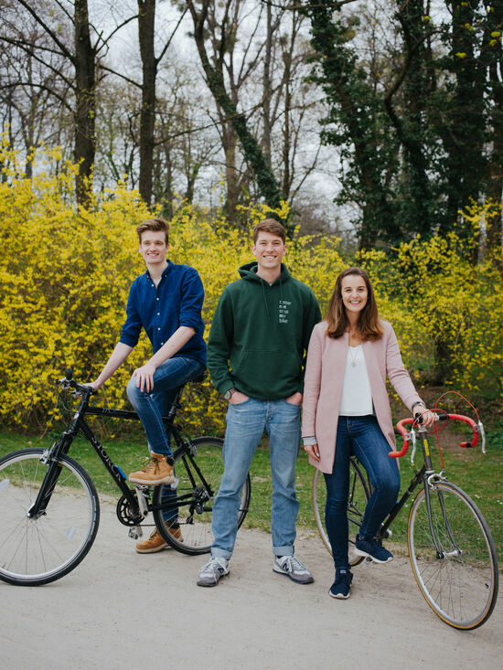 Die Studenten Kilian Schülte, Daniel Kühbacher und Annalena Willibald mit ihren Fahrrädern in einem Park