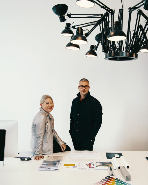 Ina and Gunther Laux at a large white desk in their architectural office