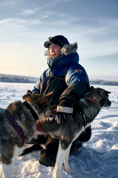 Dog sledge driver Jonas pats two of his huskies