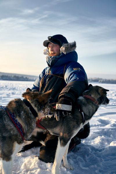 Hundeschlittenführer Jonas streichelt zwei seiner Huskys