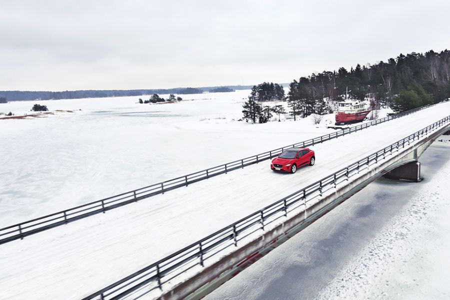 The Jaguar I-Pace drives on a snowy bridge over Finland's largest lake