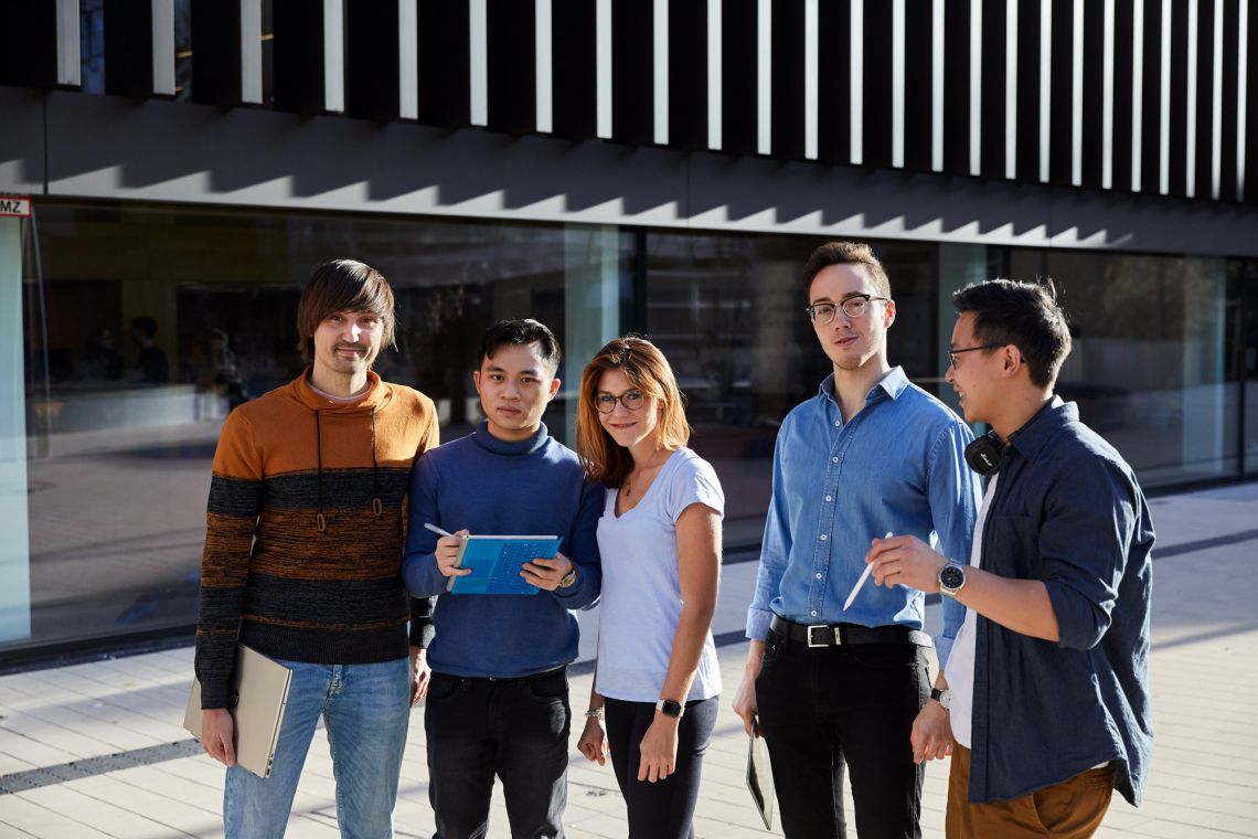 Fünf Studenten vor einem Gebäude