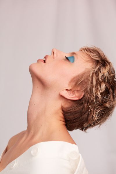 Close up of a young woman with short hair and blue eyeshadow