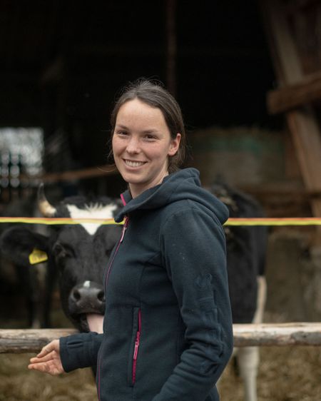 Young farmer Julia Galloth stands in front of a cowshed
