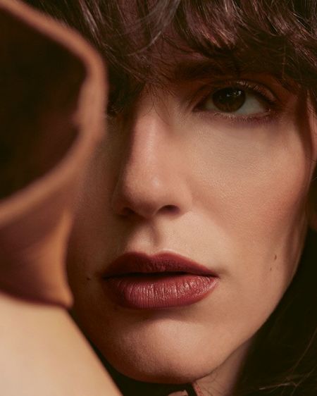 Junge Frau mit braunen Locken und rotem Lippenstift