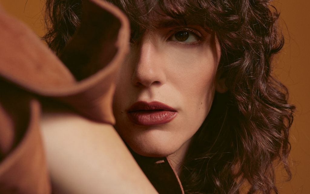 Young woman with brown curls and red lipstick