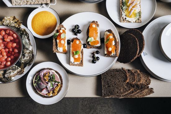 Arrangement made of small canapés, bread and gravy laid out on white porcelain plates