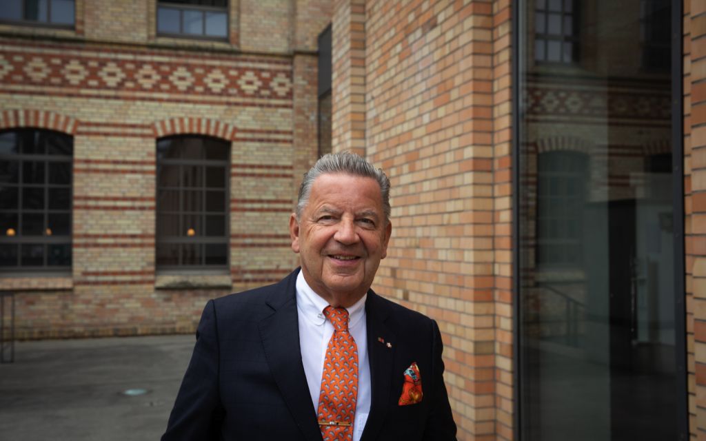 Jörg Woltmann stands smiling in the courtyard of the Royal Porcelain Manufactory Berlin