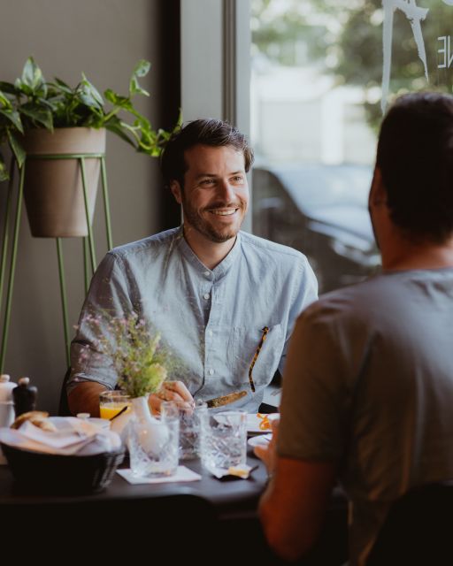 Zwei Männer sitzen beim Frühstück im Restaurant des KPM Hotel & Residences