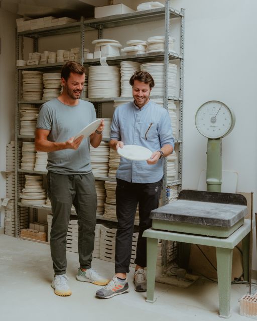 Zwei Männer betrachten Porzellanteller in der KPM Manufaktur