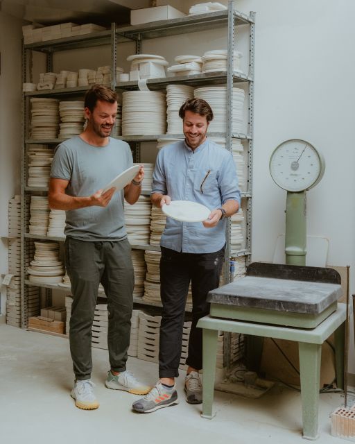 Two men looking at porcelain plates in the KPM manufactory