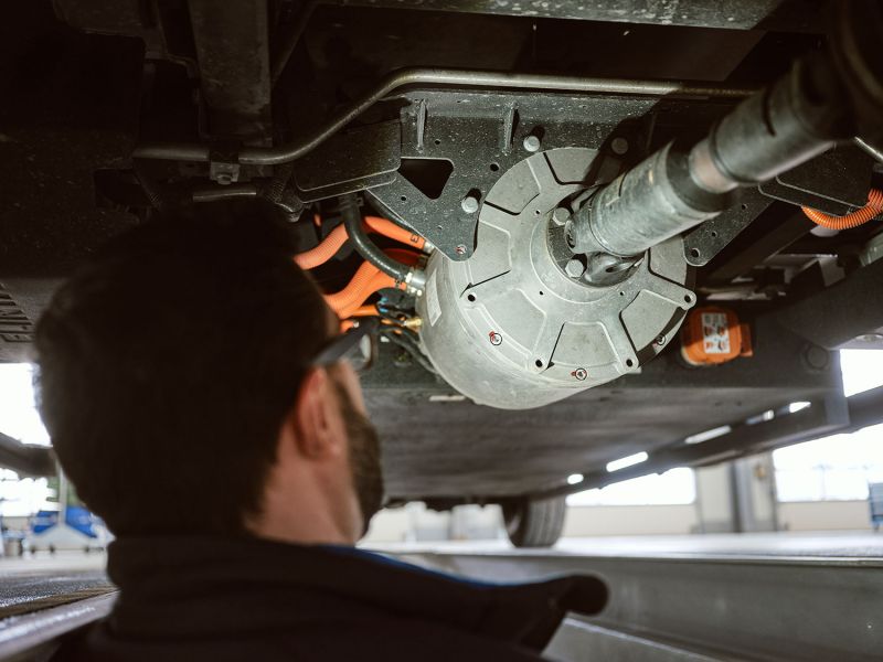 Mechanic inspects the underbody of a vehicle