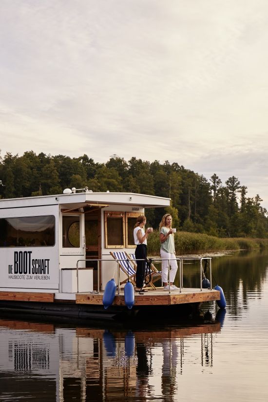 Houseboat at sunset with two women with mugs in their hand