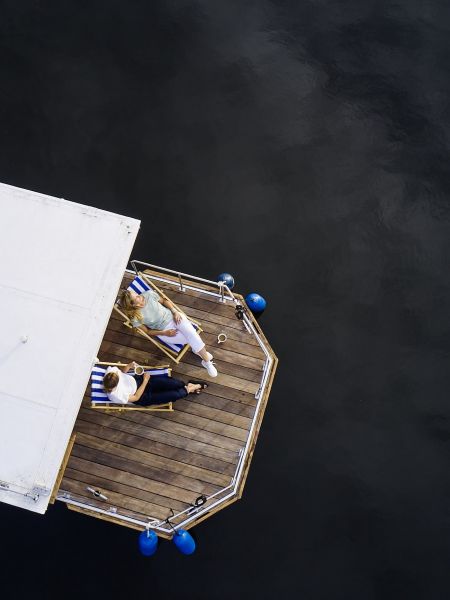 Houseboat from above while Jessica and Wiebke relax in the sun chairs
