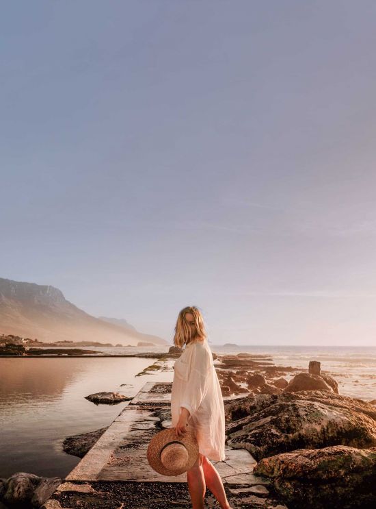 Woman on stone jetty by sea