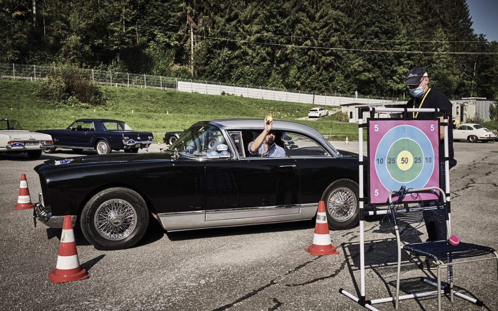 Mann im Auto wirft mit Ball auf Zielscheibe