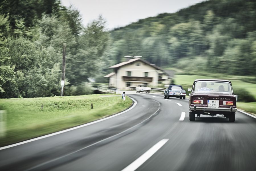 Drei Oldtimer fahren auf Landstraße