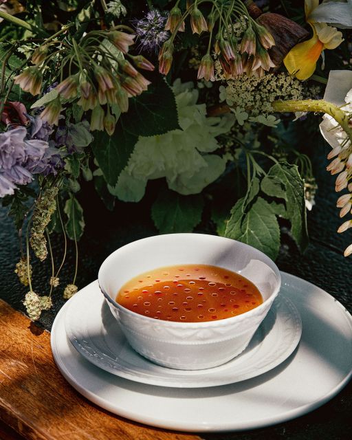 Kurland bowl and Lab plate with soup in front of flowers