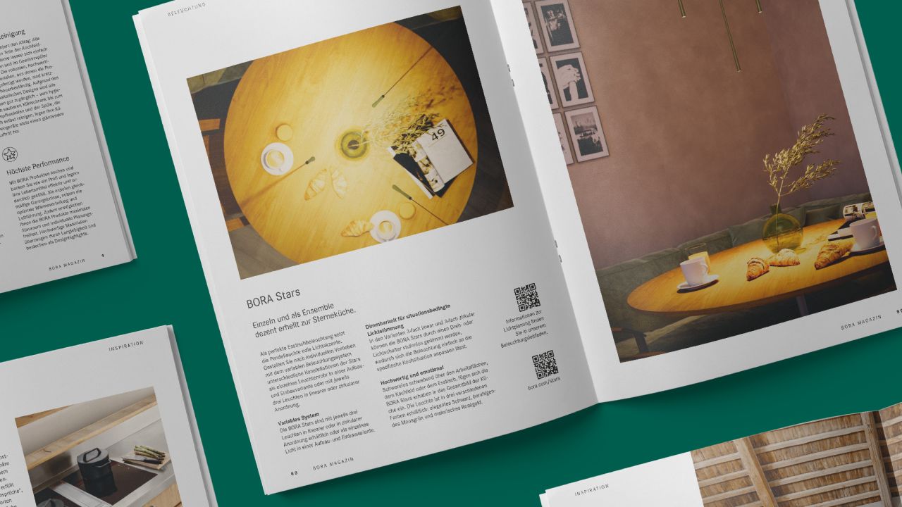 Aufgeschlagene Doppelseite des BORA Magazins 2025 mit Fotos von gedeckten Tischen in einem modernen Wohnraum Aufgeschlagene Doppelseite des BORA Magazins 2025 mit Fotos von gedeckten Tischen in einem modernen Wohnraum
