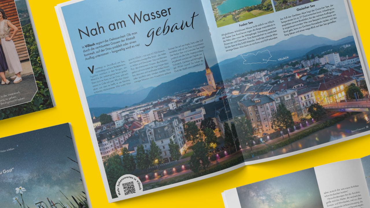 Double page from the ADAC holiday magazine supplement “Best of Austria” shows an evening shot of the city of Villach with the title “Nah am Wasser gebaut” (Built close to the water).